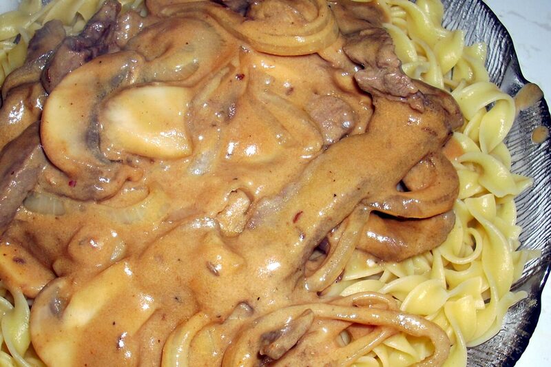 Beef stroganoff with mushrooms in creamy sauce over egg noodles