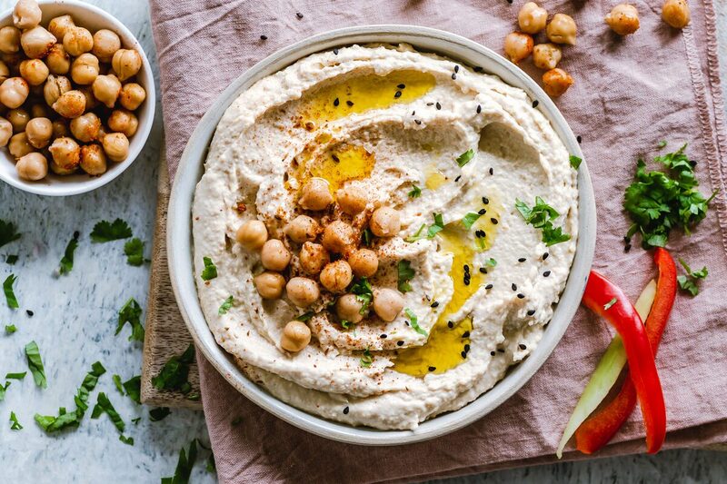 Bowl of hummus drizzled with olive oil and dusted with paprika