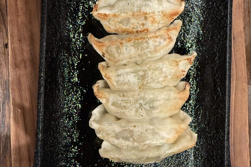 Pan-fried dumplings with crisp golden bottoms on a plate