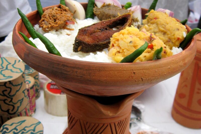 Bowl of panta bhat (fermented rice) with fried Ilish fish, onion, and green chili