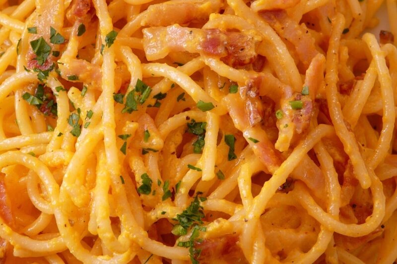 Spaghetti carbonara twisted on a fork with black pepper and pecorino